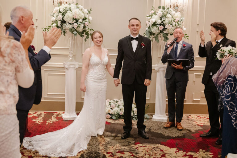 Applause at a ballroom wedding ceremony with the couple and wedding party