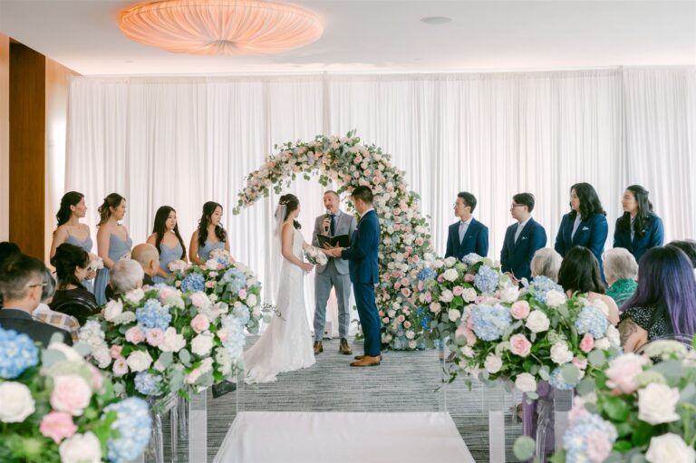 A couple celebrating with raised arms after their indoor ceremony