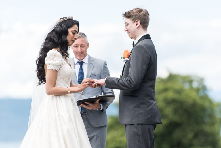 A couple exchanging vows between tall floral pillars