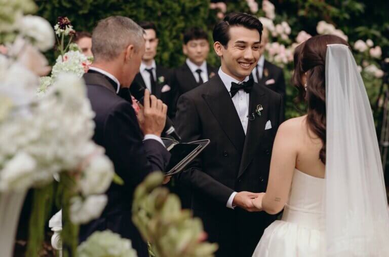 Jonathan Evans officiating as Nick and Lindsay hold hands during their ceremony